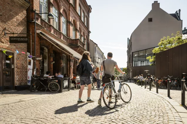 Cyclist and pedestrian on a street in central Lund.